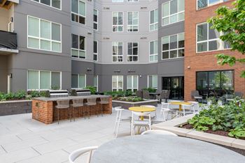 a patio with tables and chairs at the bradley braddock road station apartments
